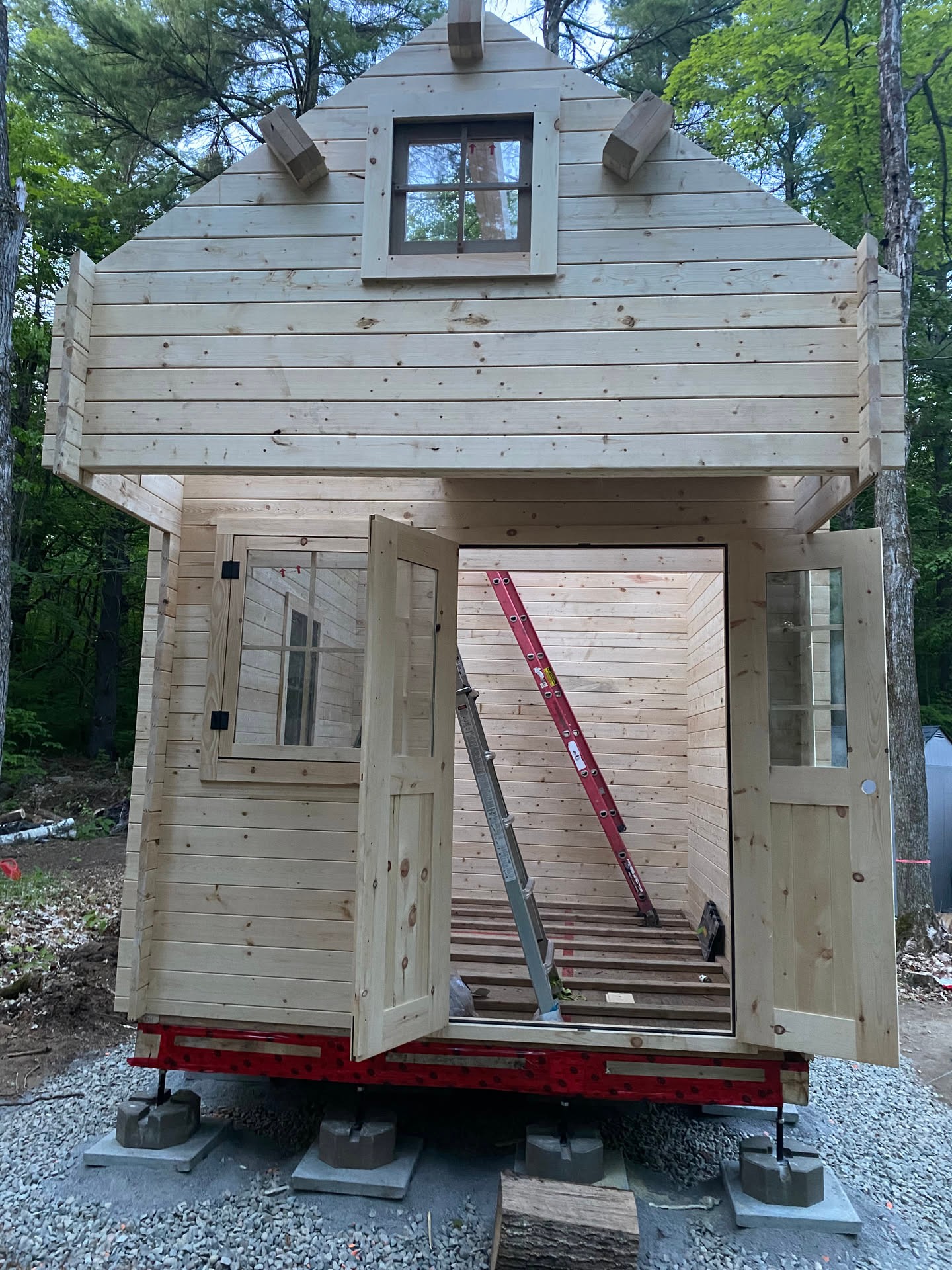 A look back at the shed build taking shape in the trees, still raw pine, open doors, and ladders inside. Even before it was finished, it alr…