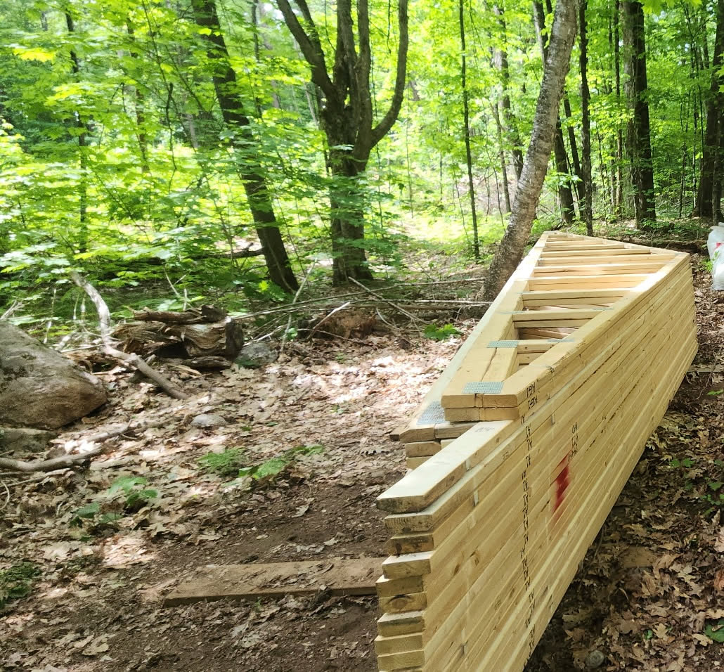 Our freshly engineered roof trusses nestled along the forest edge, ready for the next part of the build Quiet and methodical work under the…