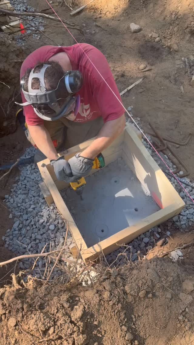 Drilling out holes in the bedrock for rebar, which will reinforce the concrete against the bedrock and provide protection from frost