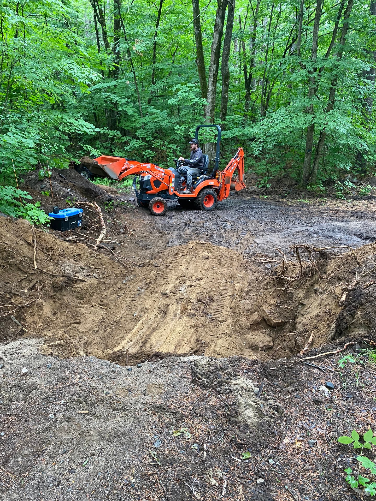 A look back at reshaping the driveway slope in the woods, widening the approach one bucket at a time. Quiet land work, muddy tracks, and a l…