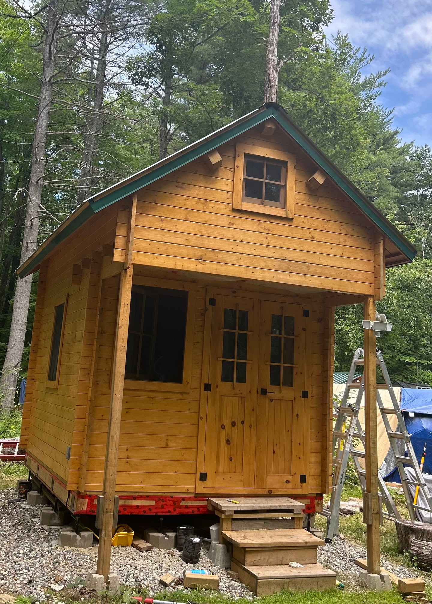 A look back at the bunkie coming together in the summer woods, fresh cedar walls tucked under the trees while the last pieces of the build w…